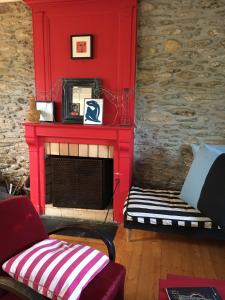 ein Wohnzimmer mit einem roten Kamin und einem Sofa in der Unterkunft Maison de famille sur l'île de Groix in Groix