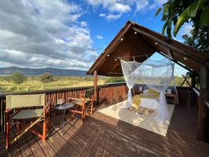 a deck with a canopy bed and a table and chairs at Tandweni Villa in Pongola Game Reserve