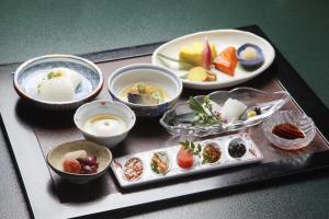 taca z jedzeniem z miskami i talerzami z jedzeniem w obiekcie Chikuba Shinyotei w mieście Hakodate