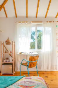 silla en una habitación con escritorio y ventana en CABAÑA LA PALMERITA en Playa El Palmar en El Palmar