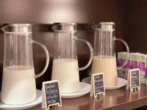 two glass containers filled with milk on plates on a shelf at SM Hotel Sant Antoni in Barcelona