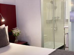 a bedroom with a glass shower and a bed at SM Hotel Sant Antoni in Barcelona