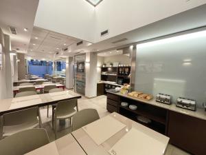 a dining room with tables and chairs and a kitchen at SM Hotel Sant Antoni in Barcelona