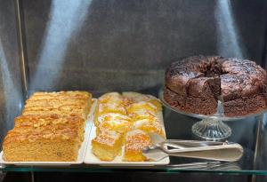 a glass display case with cakes and a chocolate cake at SM Hotel Sant Antoni in Barcelona