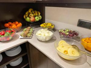 a kitchen counter with bowls of fruits and vegetables at SM Hotel Sant Antoni in Barcelona