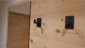 eine Holzwand mit einem Spiegel und einer Holztür in der Unterkunft Bucherwirt Appartements in Buch bei Jenbach