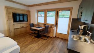 a kitchen with a desk and a sink in a room at Bucherwirt Appartements in Buch bei Jenbach