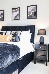 a bedroom with a bed and a nightstand with a lamp at Ted House - Long Stay Discount in Royal Tunbridge Wells