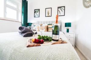 a bottle of wine sitting on top of a bed at Ted House - Long Stay Discount in Royal Tunbridge Wells