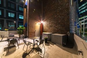 a patio with chairs and tables and a brick wall at Soosong Guesthouse in Seoul