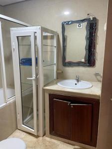 ein Bad mit einem Waschbecken und einem Spiegel in der Unterkunft Appartement au bord de l'eau in Mohammedia