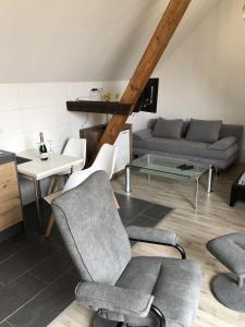 a living room with a couch and chairs and a table at Apartment am Stettiner Haff in Mönkebude