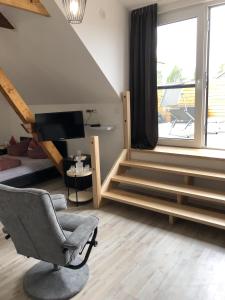 a living room with a staircase and a chair at Apartment am Stettiner Haff in Mönkebude