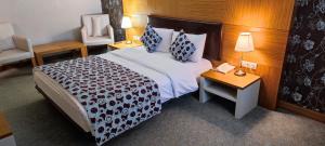 Habitación de hotel con cama y mesa con teléfono en Grand Nur Plaza Hotel, en Aktau