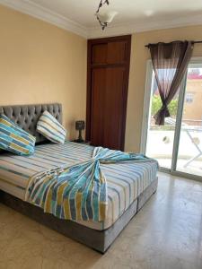 a bedroom with a large bed with a large window at Appartement au bord de l'eau in Mohammedia