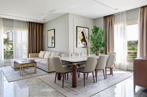 a living room with a couch and a table and chairs at VESTA - Cairo Festival City Residence in Cairo