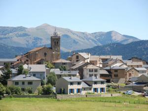 a town with a church and mountains in the background at Studio Les Angles, 1 pièce, 4 personnes - FR-1-758-4 in Les Angles