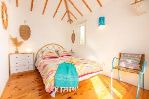 1 dormitorio con 1 cama y 1 silla en CABAÑA LA PALMERITA en Playa El Palmar, en El Palmar