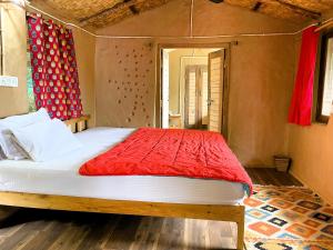 - une chambre avec un lit et une couette rouge dans l'établissement Quiet Place Himalayas, à Mukteswar