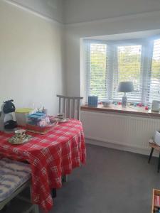 a room with a table with a red plaid table cloth at Luxurious Private Accommodation Manchester Airport Stay Park And Fly Lyme Park in Hazel Grove