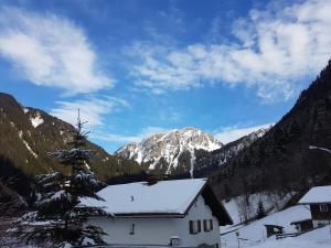 a white house with a snow covered mountain in the background at Haus Stehbock in Partenen