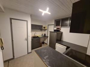 a kitchen with a black counter top in a room at Le repaire d'Odin - au coeur du centre ville in Saint-Claude