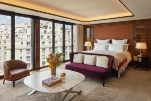 パリにあるBulgari Hotel Parisのベッド、ソファ、テーブルが備わるホテルルームです。