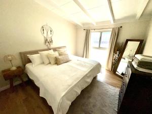 een slaapkamer met een bed met witte lakens en een raam bij King Suite near SpaceX, SoFI, LAX and Sout Bay Beaches in Gardena
