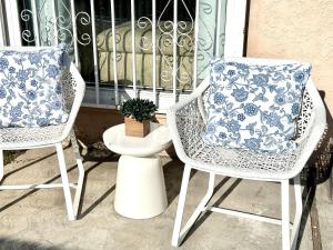 twee stoelen en een kussen op een veranda bij King Suite near SpaceX, SoFI, LAX and Sout Bay Beaches in Gardena