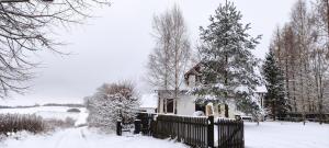 een huis met een hek in de sneeuw bij Wyskok 1 - dom z widokiem in Srokowo