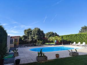a swimming pool in a yard with chairs around it at La Triqueta Casa Rural con Piscina y Barbacoa, ideal para familias y grupos in Zarzuela del Monte