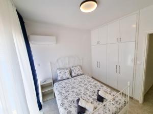ein kleines Schlafzimmer mit einem Bett und weißen Schränken in der Unterkunft Beach Vibes Apartment in Pyla