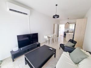 ein Wohnzimmer mit einem Sofa und einem Tisch in der Unterkunft Beach Vibes Apartment in Pyla
