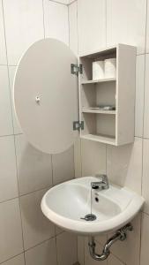 a bathroom with a white sink and a mirror at Villa Ku Villa Mu in Semarang