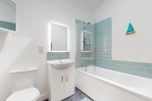y baño con lavabo, aseo y bañera. en Superb Panoramic Sea Views Sleeps 10 Pet Friendly, en Woolacombe