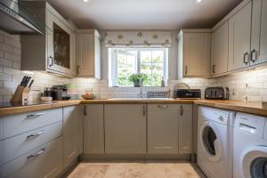 a kitchen with a sink and a washing machine at 2 bed garden cottage nestled on the edge of Exmoor in Bishops Nympton