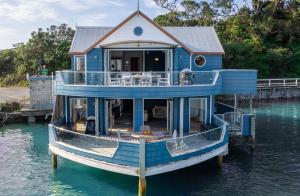 a blue house boat sitting in the water at Bay of Islands 2 Bedrooms On The Water-The Landing in Opua