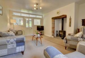 a living room with two couches and a fireplace at 2 bed rural retreat nestled in the heart of Exmoor in Parracombe