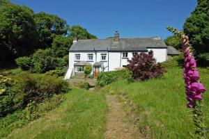 a white house on a hill with a dirt road at 2 bed rural retreat nestled in the heart of Exmoor in Parracombe