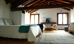 ein Wohnzimmer mit einem Bett, einem Tisch und Fenstern in der Unterkunft B&B Allo Spizzo in Valstagna