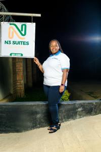 a woman sitting on a ledge holding a sign at The N3 Suites in Mzuzu