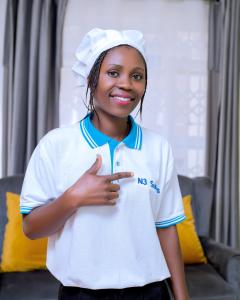 una mujer joven usando un sombrero de chef y sonriendo en The N3 Suites, en Mzuzu