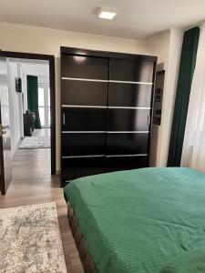 um quarto com uma cama grande e um armário preto em Apartament Sonya em Bucareste