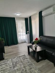 uma sala de estar com um sofá de couro preto e uma mesa em Apartament Sonya em Bucareste