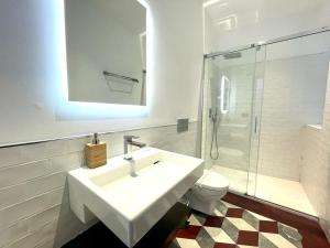 a white bathroom with a sink and a toilet at Eva Recommends Triana in Seville