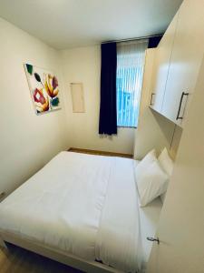 een groot wit bed in een kamer met een raam bij Urbanstay Suites Apartment In Charming Sablon in Brussel