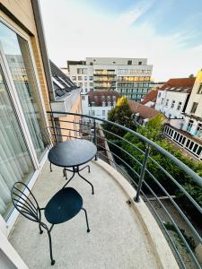 een tafel en stoelen op een balkon met uitzicht bij Urbanstay Suites Apartment In Charming Sablon in Brussel