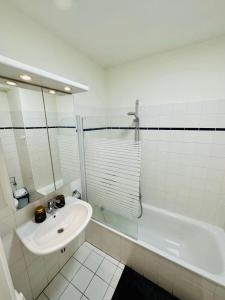 bagno con lavandino, doccia e vasca di Urbanstay Suites Apartment In Charming Sablon a Bruxelles