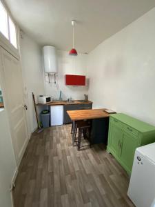 a kitchen with a wooden table and green cabinets at Studio hypercentre ralliement in Angers