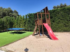 un parco giochi con scivolo rosso e tavolo blu di La Triqueta a Zarzuela del Monte